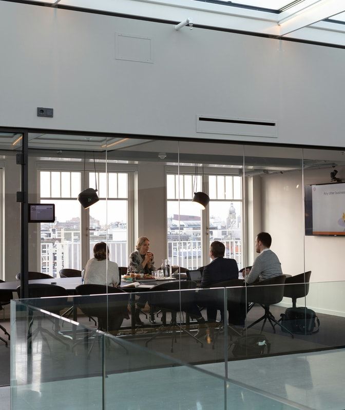 A team meeting in a bright glass-walled conference room